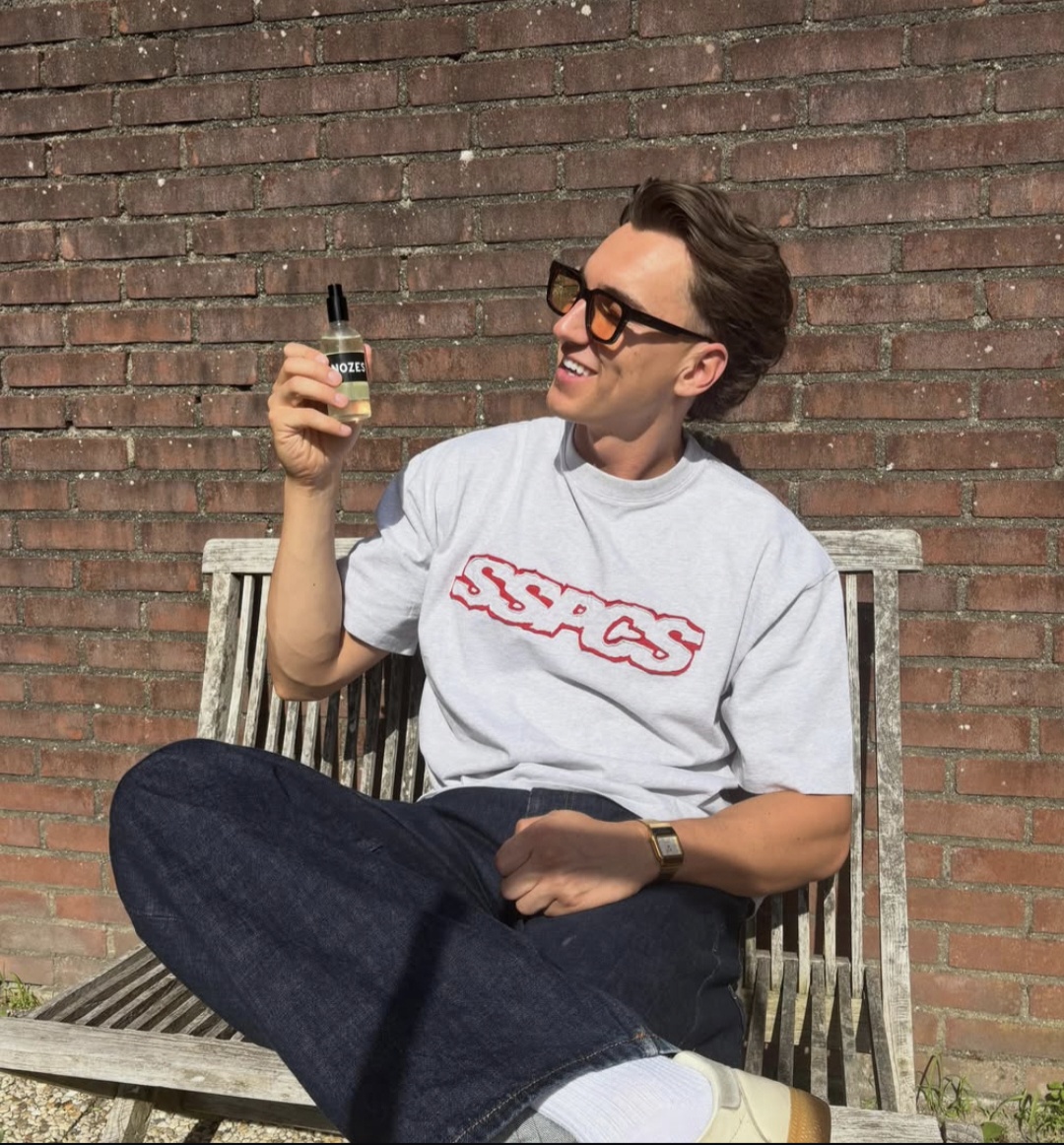 Man in de zon met een flesje Nozes in de hand